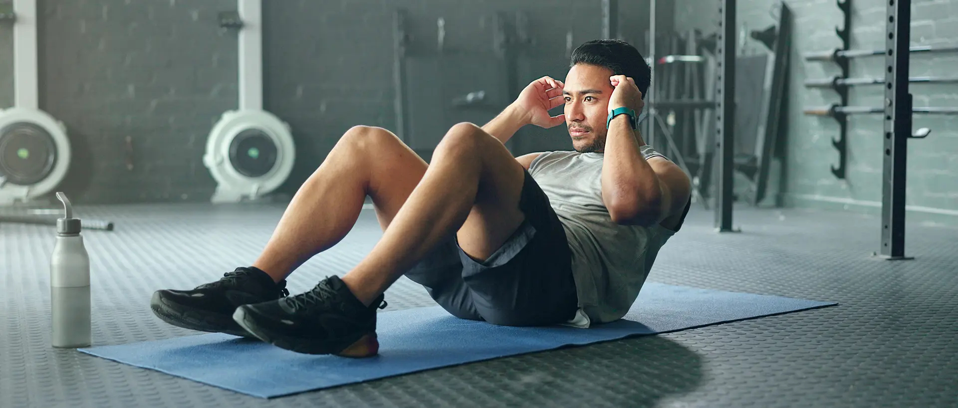 A man practises sit-ups in a gym