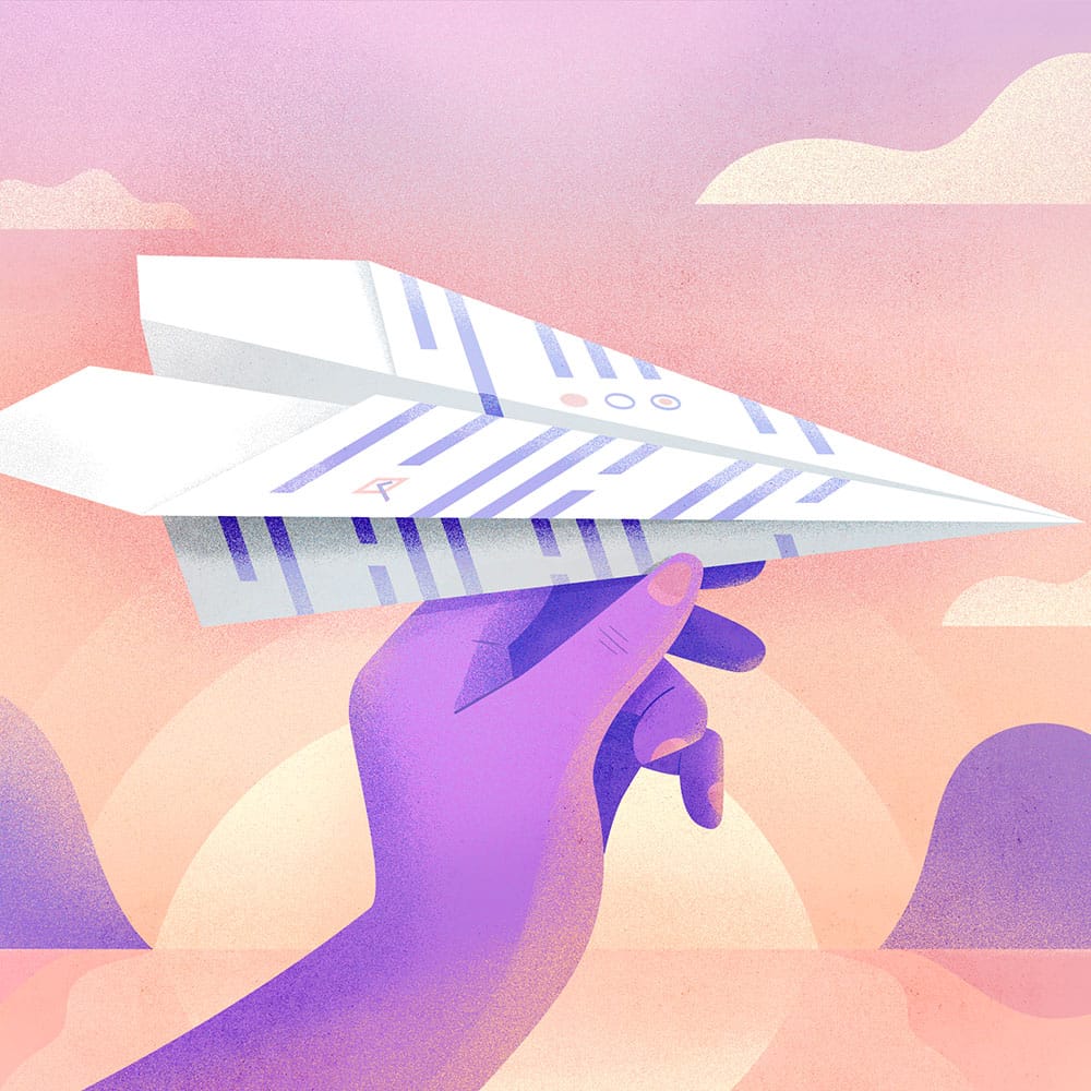 Main qui tient un avion en papier avec un coucher de soleil en arrière-plan