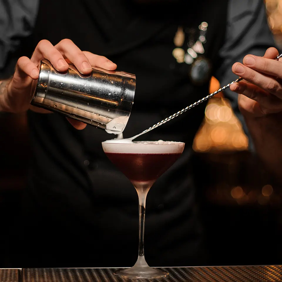 A barman prepares a cocktail in a club