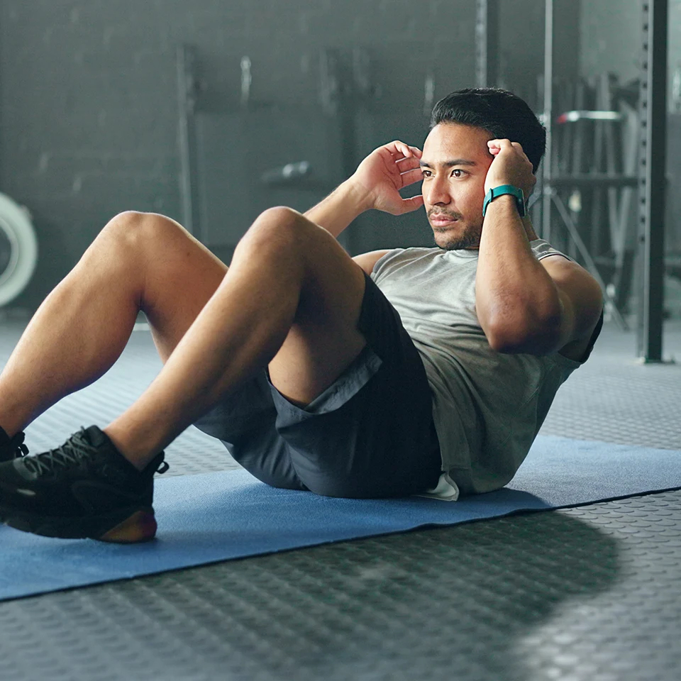 A man practises sit-ups in a gym